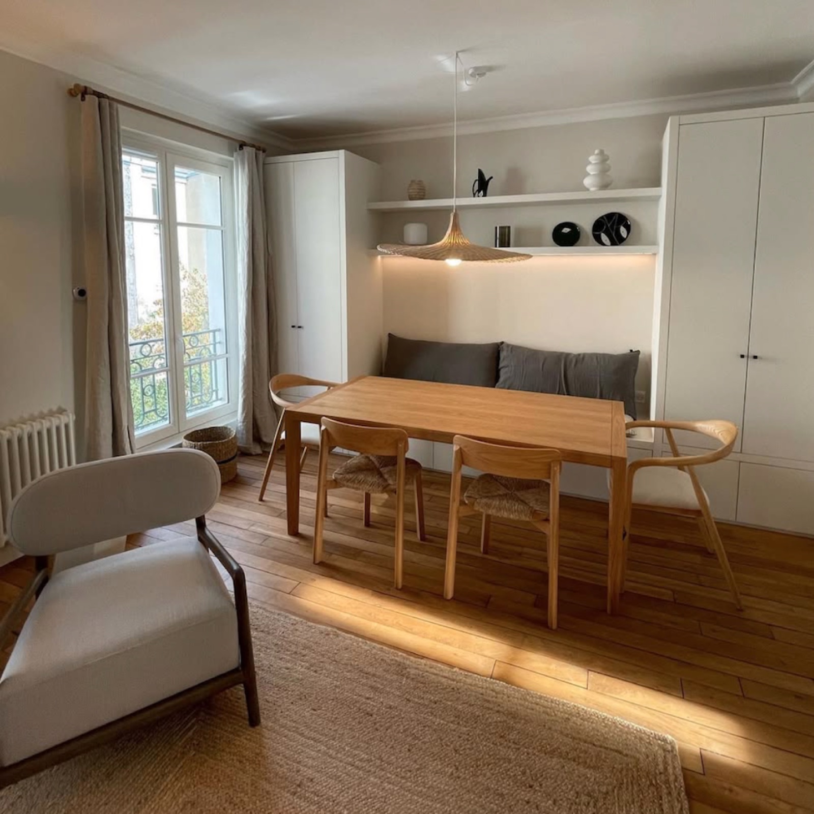 Salle à manger rénovée : banquette intégrée entre rangements toute hauteur, parquet massif